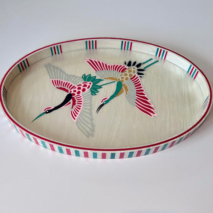 An oval mother of pearl Decorative tray with a pink crane design. Alara London
